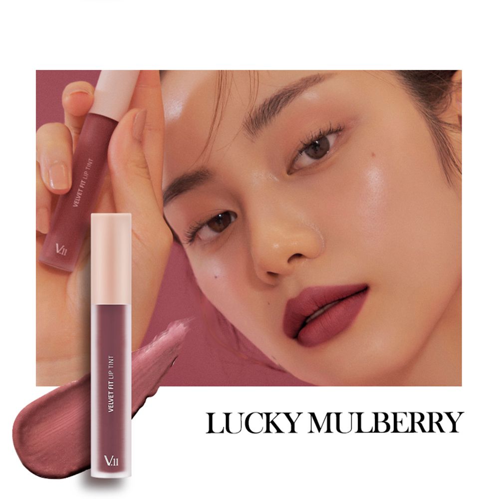 Flacone di tinta labbra Lucky Mulberry. Testo: Velvet Fit Lip Tint. Applicazione sul viso di una donna. Prodotto applicato.