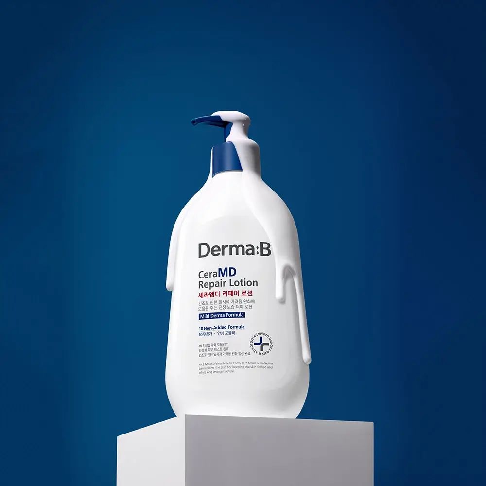 Flacone bianco con erogatore blu. Scritta: Derma:B CeraMD Repair Lotion. Prodotto su piedistallo, sfondo blu.