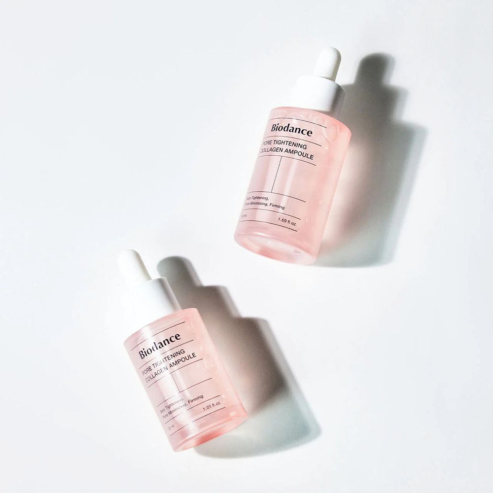 Due flaconi rosa con tappo bianco. Scritta: Biodance PORE TIGHTENING COLLAGEN AMPOULE. Ombre.