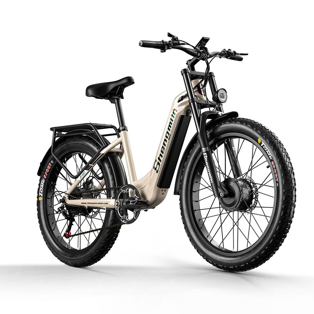 E-bike beige con pneumatici neri e portapacchi. Marchio Shengmilo visibile. Faro anteriore e sospensioni.