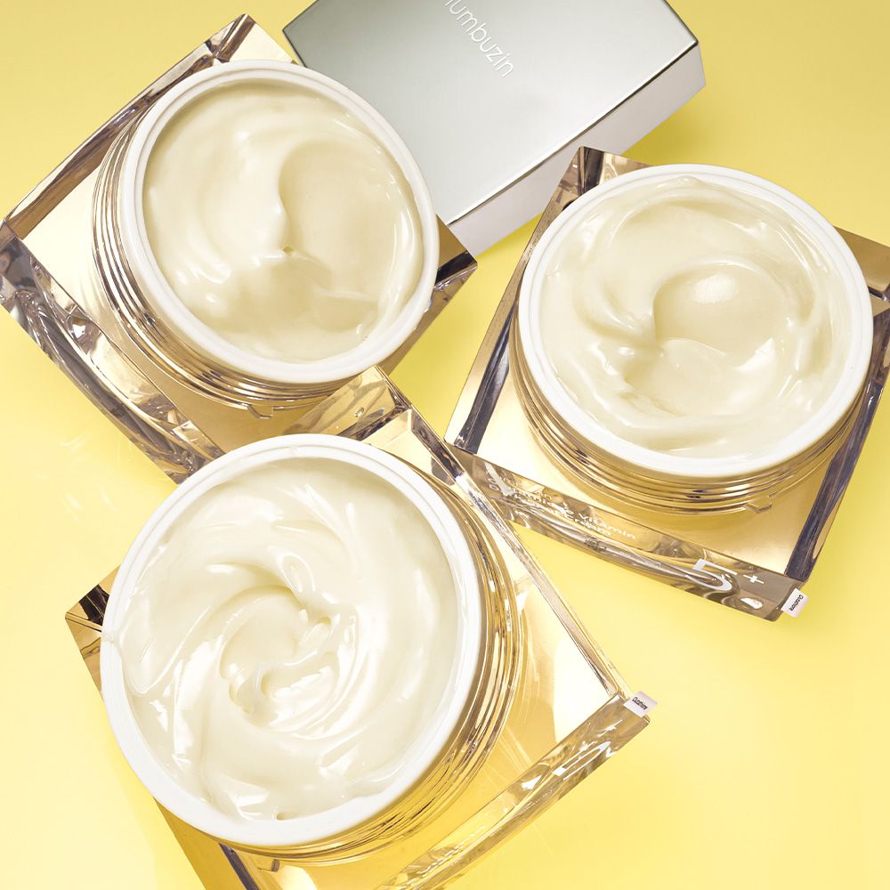 Tre vasi aperti di NUMBUZIN Nr.5 Vitamina Glutatione Crema Laser Macchie Scure su sfondo giallo.