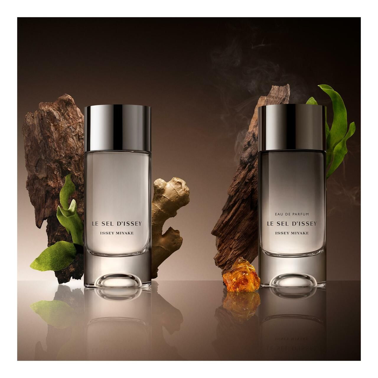 Due flaconi di profumo accanto a legno, zenzero e ambra. Scritta: Le Sel d'Issey, Issey Miyake.