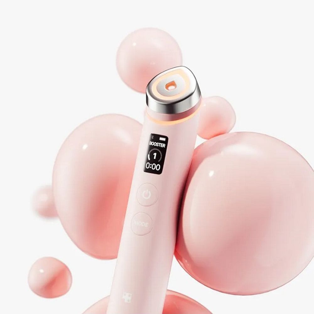 Bacchetta di bellezza rosa con testa arancione. Sferette rosa sullo sfondo.