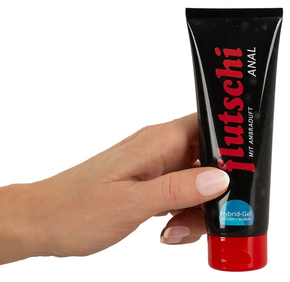 Mano che tiene un tubo nero con scritta rossa: Flutschi Anal. Il gel viene spremuto dall'apertura.