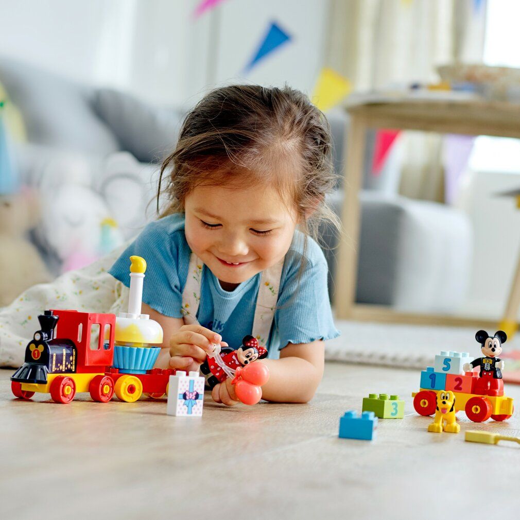 Bambina gioca con LEGO Duplo 10941. Trenino di Topolino e Minnie. Trenino, Topolino, Minnie, Pluto, regalo e blocchi.
