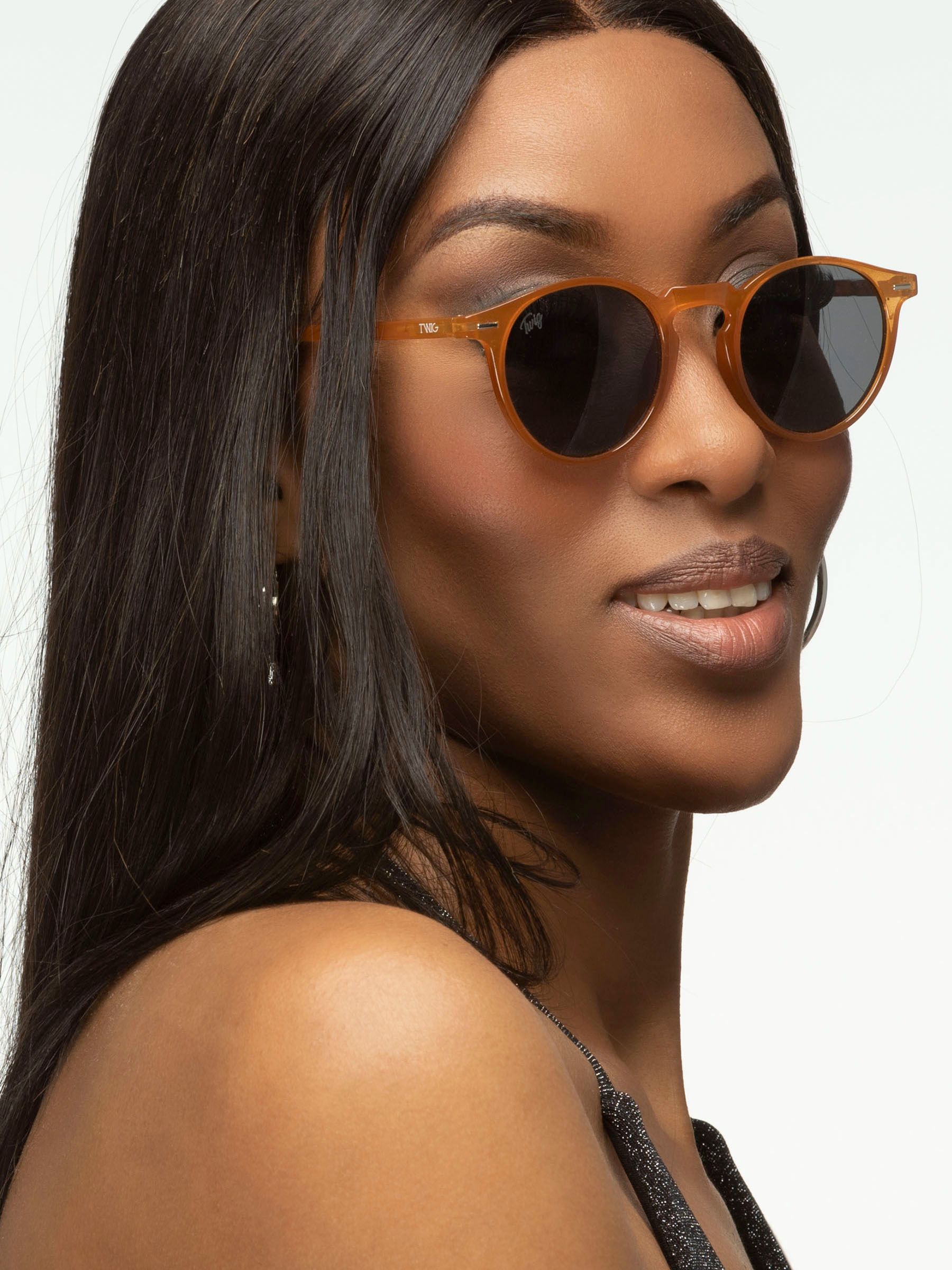 Donna con occhiali da sole marroni e lenti scure. Primo piano.