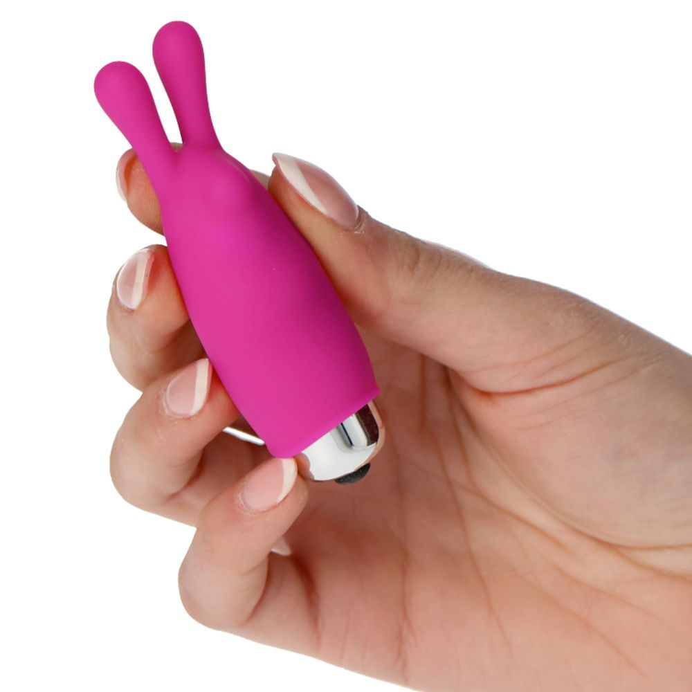Vibratore rosa con due sporgenze a forma di orecchie. Punta metallica. Tenuto in mano.