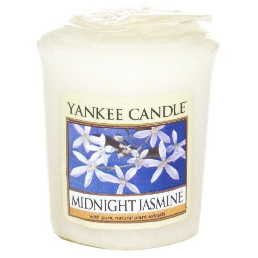 Candela profumata Yankee Candle Midnight Jasmine. Bicchiere di candela bianco con etichetta. Etichetta con motivo floreale e testo.
