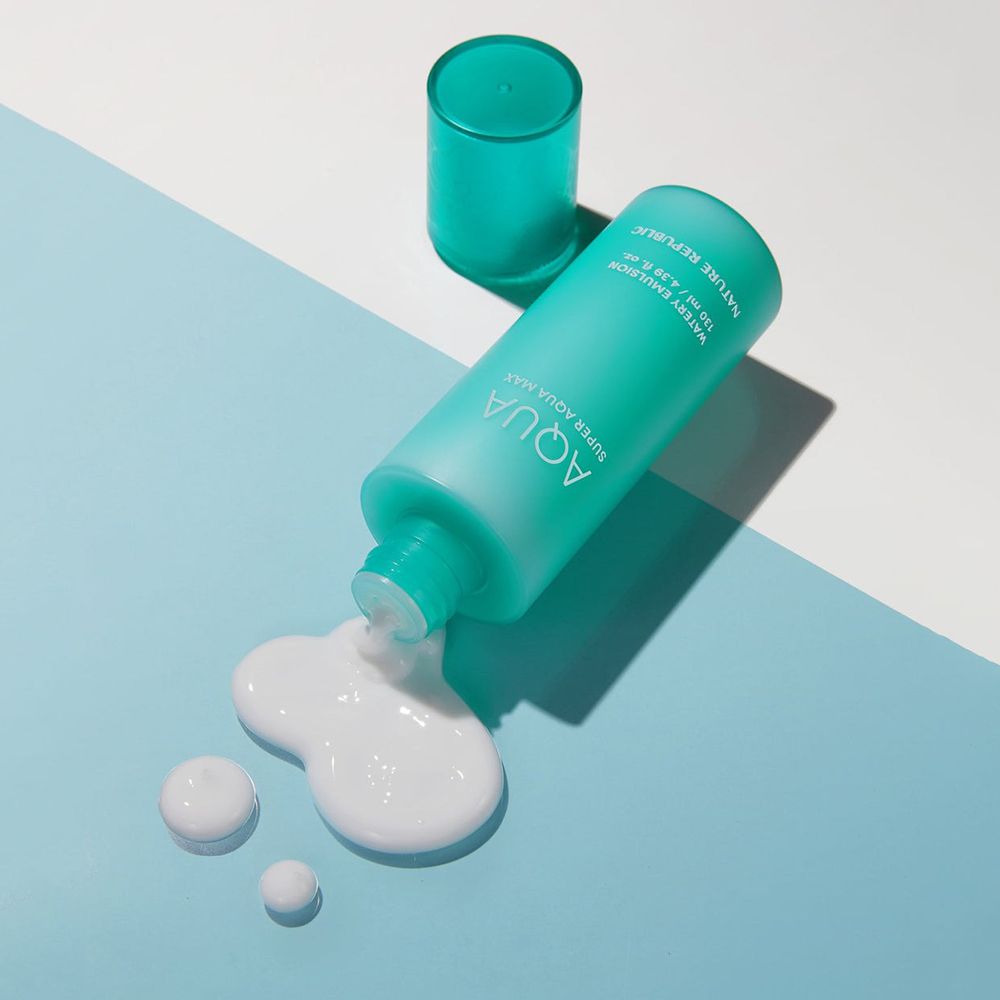 Bottiglia turchese con emulsione bianca su sfondo blu. Coperchio accanto. Nome del prodotto visibile.