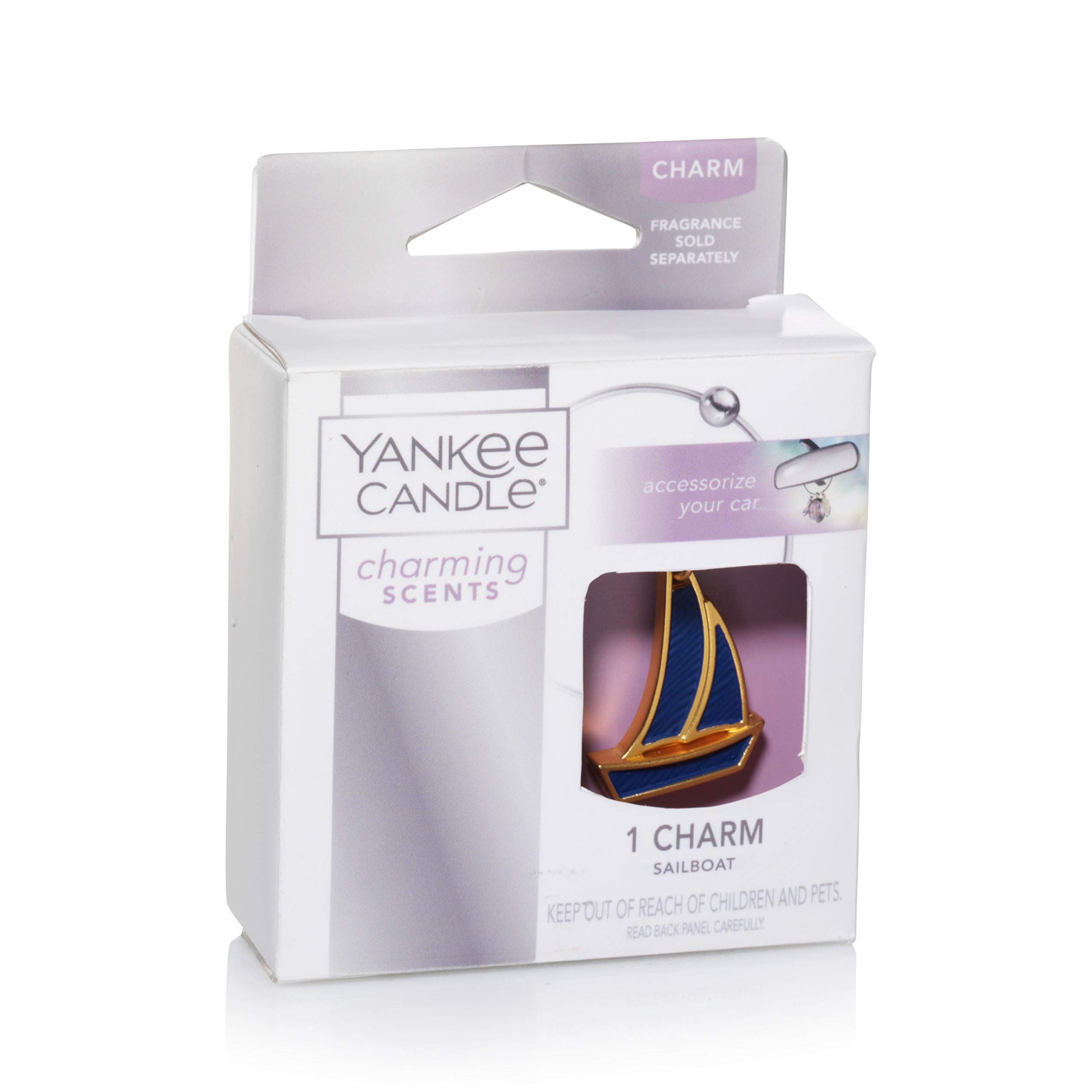 Confezione con charm a forma di barca a vela. Charm oro e blu. Marchio: Yankee Candle.