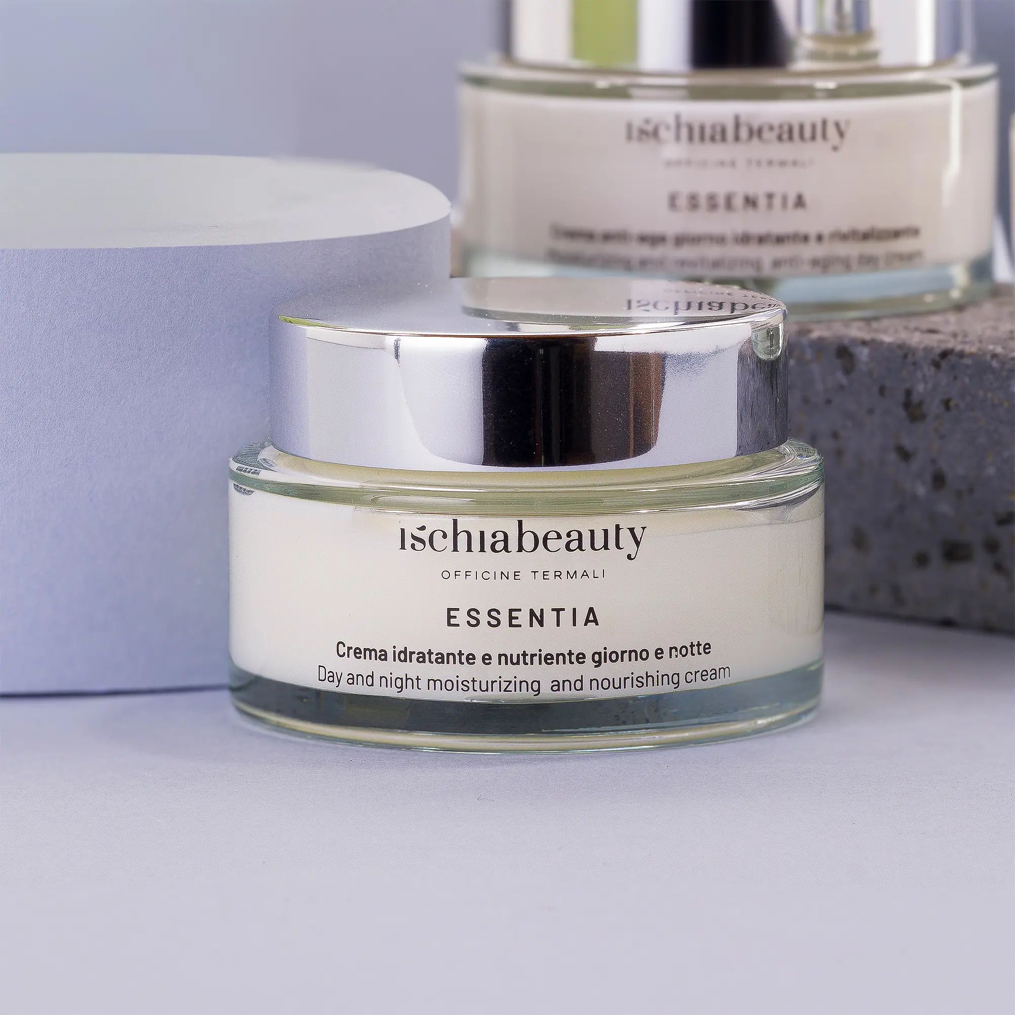 Vasetto di crema con coperchio argentato. Scritta: ischiabeauty, ESSENTIA. Testo: Crema idratante e nutriente giorno e notte.