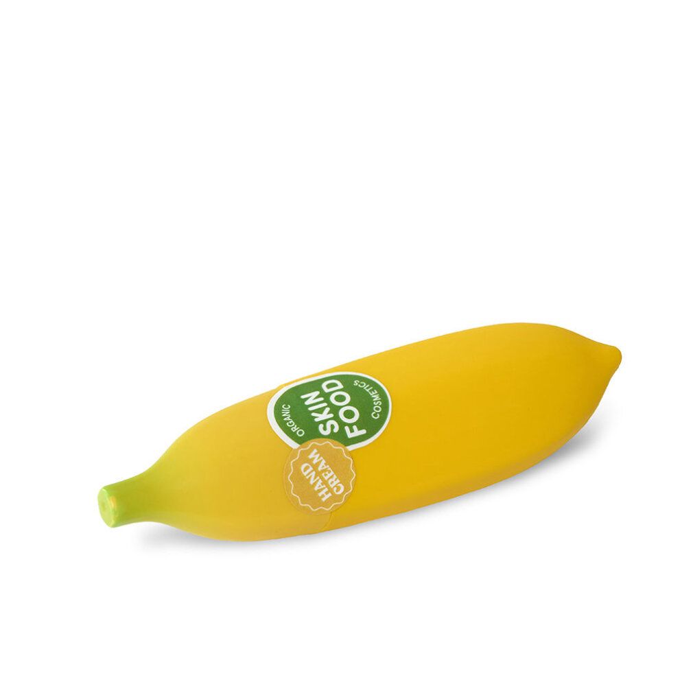 Tubo di crema mani giallo a forma di banana con adesivi verdi e gialli. Scritta: Skin Food, Hand Cream.