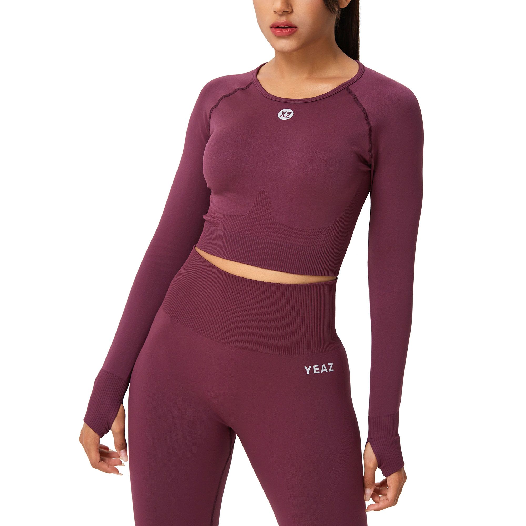 Completo viola con crop top a maniche lunghe e fori per i pollici, e leggings coordinati con logo.
