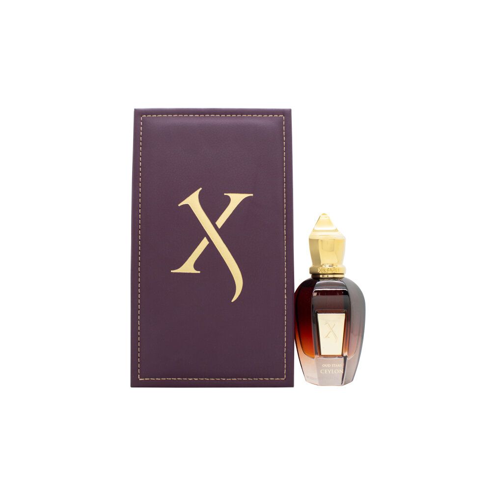 Flacone di profumo e confezione. Flacone marrone, tappo dorato. Confezione viola con logo dorato.