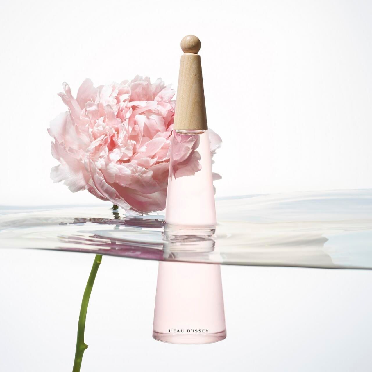 Flacone rosa, tappo in legno, peonia, acqua. L'Eau d'Issey.