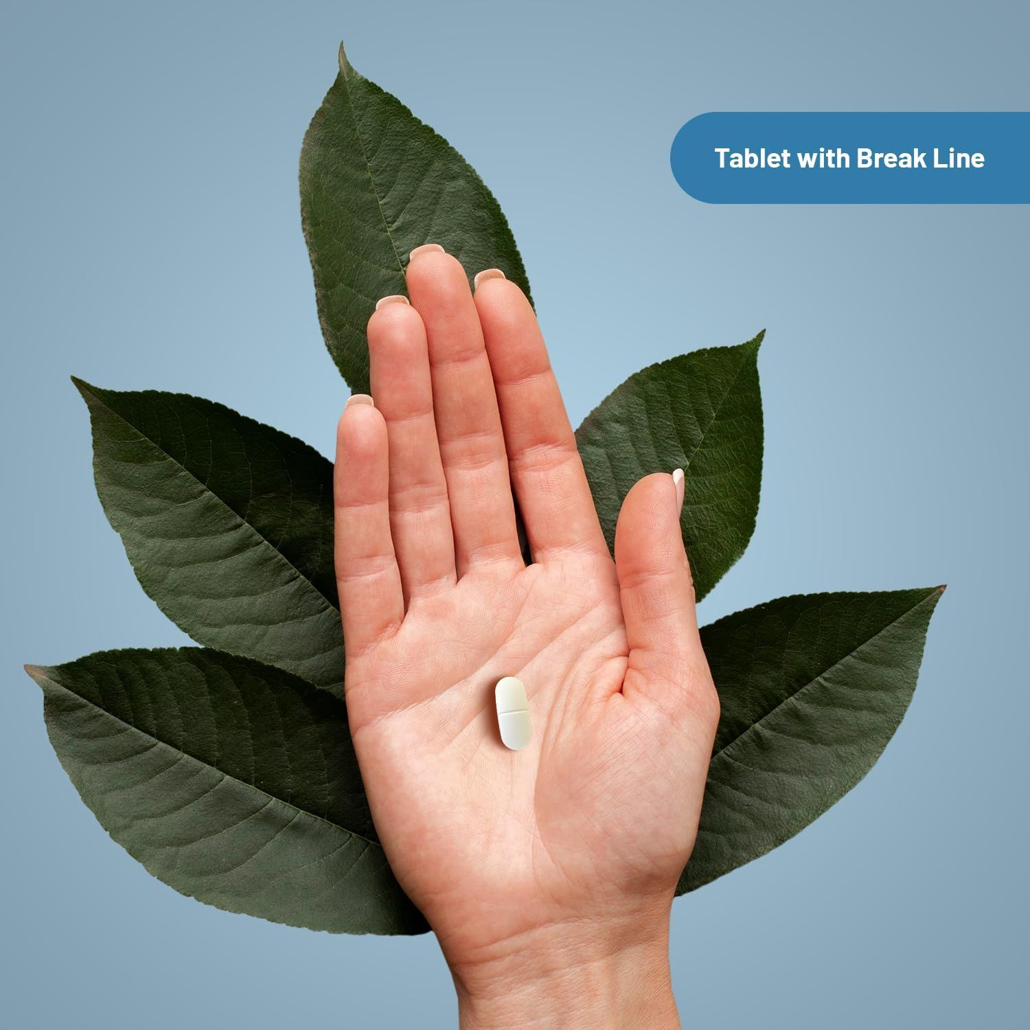 Mano con compressa su foglie verdi. Compressa con linea di rottura. Sfondo azzurro.