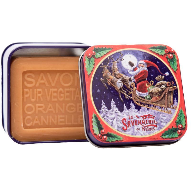 Scatola di metallo con sapone. Scatola aperta con sapone quadrato. Sul coperchio: motivo natalizio con Babbo Natale e renne. Testo: La Savonnerie de Nyons.