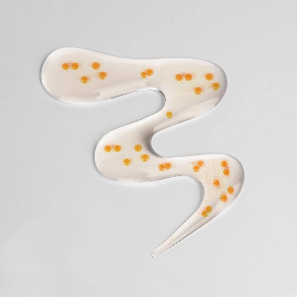 Traccia di siero ondulata con piccole capsule gialle. Su sfondo bianco.