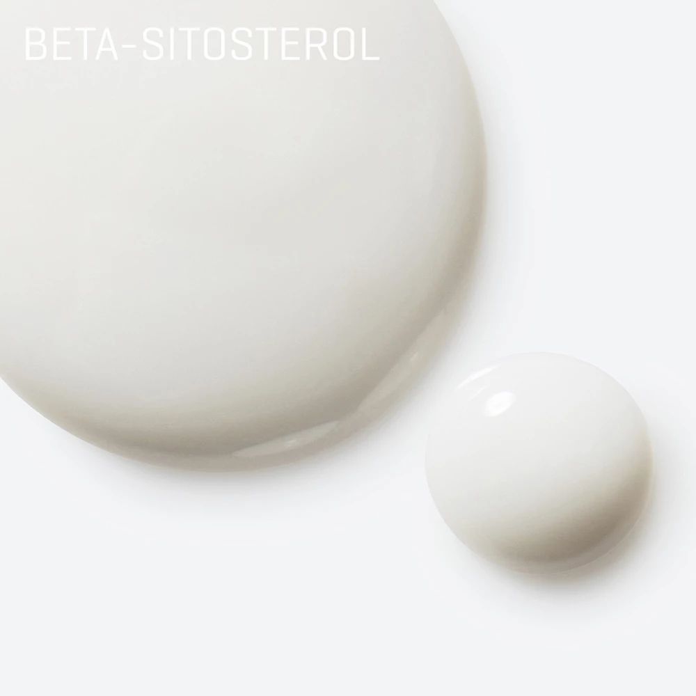 Primo piano di due gocce di siero bianco. Scritta: Beta-Sitosterol. Sfondo bianco.
