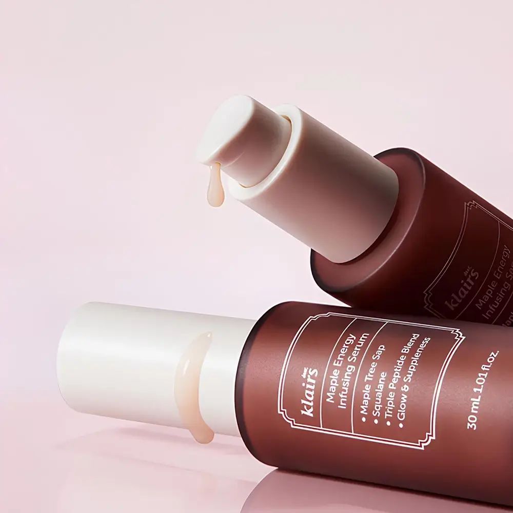 Due flaconi marroni con tappi bianchi. Gocce di siero. Scritta: Klairs Maple Energy Infusing Serum.