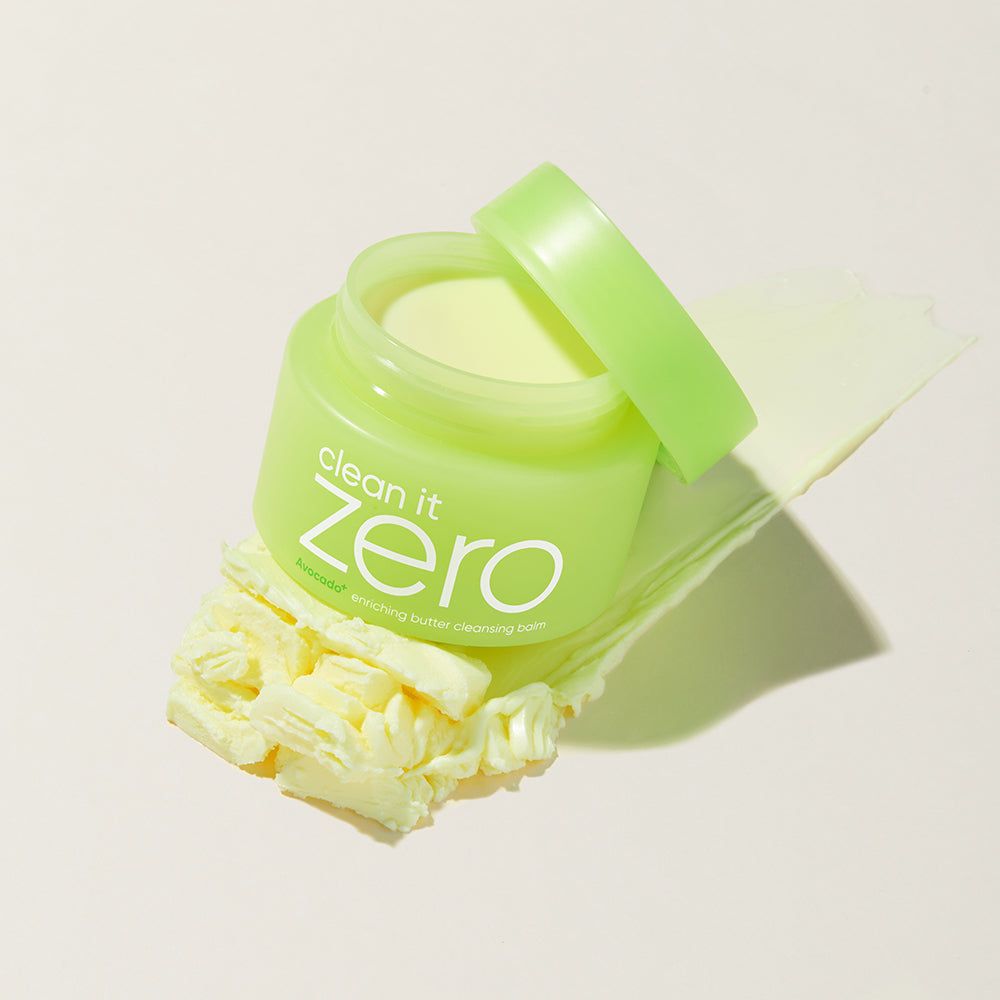 Contenitore verde con coperchio aperto, accanto a una consistenza burrosa e una striscia.