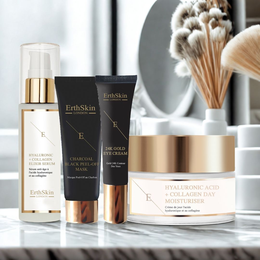 Prodotti cosmetici: siero, maschera, crema occhi e crema giorno. Confezioni nere e oro. Testo: ErthSkin London. Su marmo.