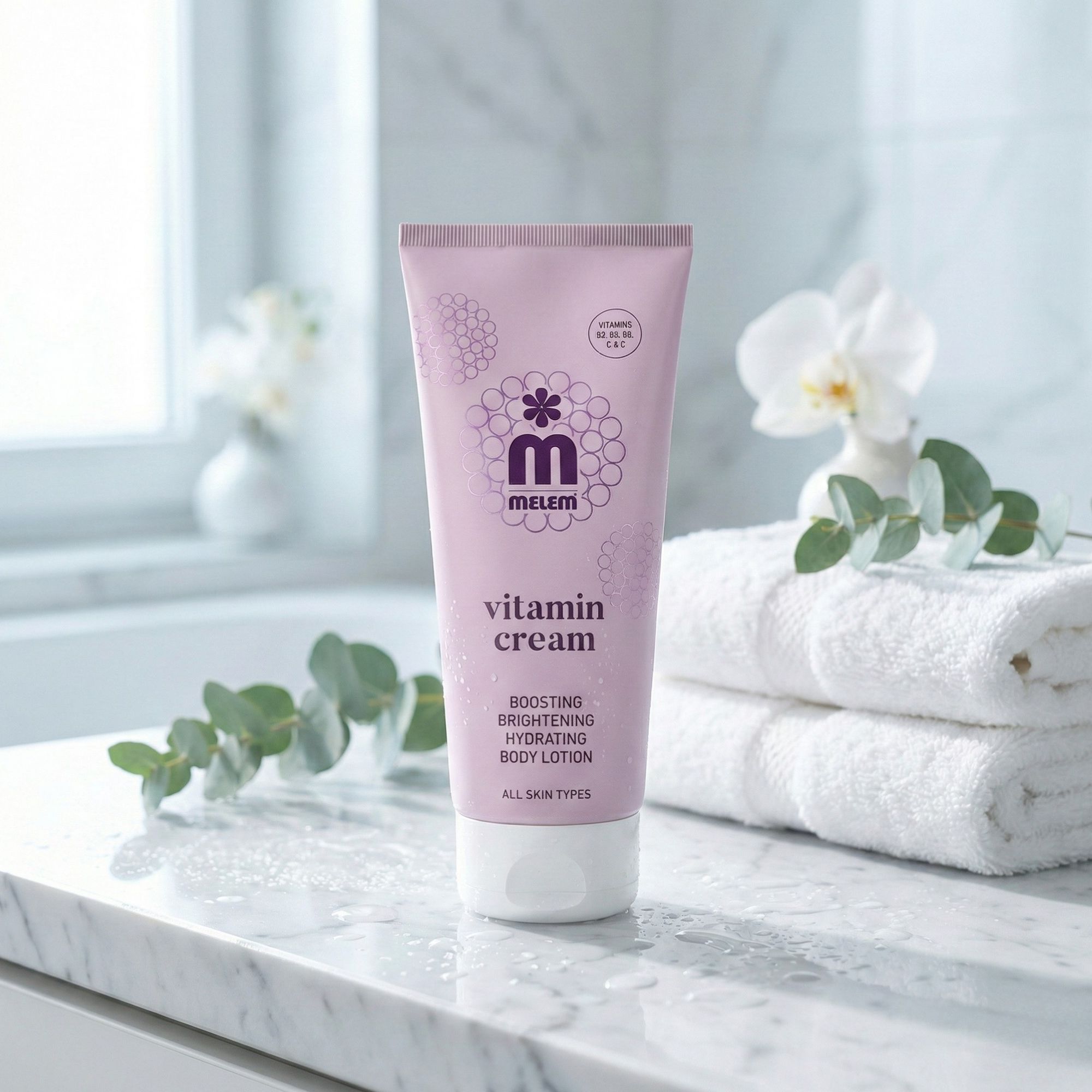 Tubo rosa con tappo bianco. Scritta: Melem Vitamin Cream. Testo: Boosting, Brightening, Hydrating Body Lotion. Per tutti i tipi di pelle.