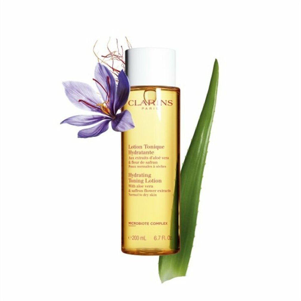 Clarins Lotion Tonique Hydratante. Bottiglia con liquido giallo, fiore e foglia. Testo sull'etichetta.