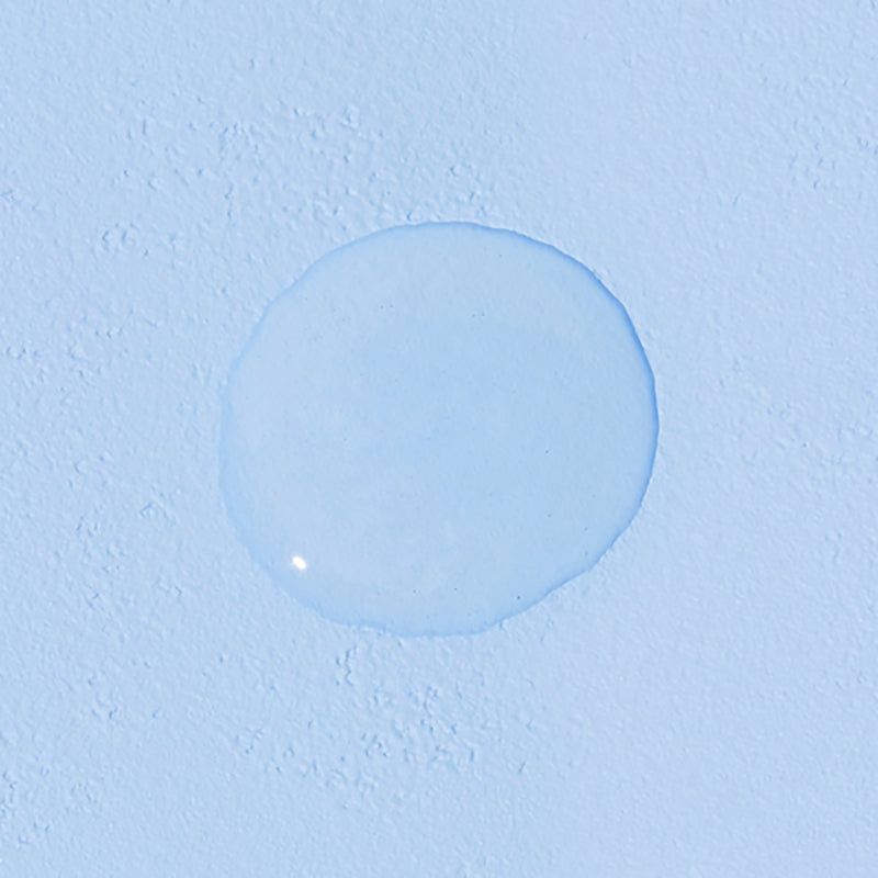Goccia rotonda di liquido su sfondo blu. Nessuna informazione sul prodotto visibile.