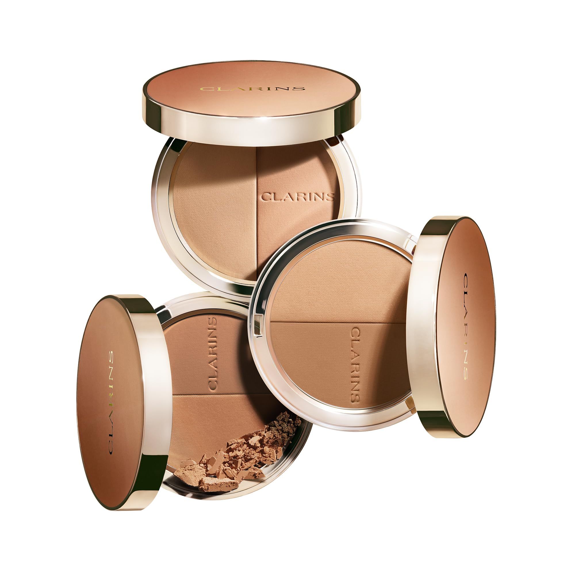 Tre ciprie bronzanti compatte. Due aperte, una con polvere. Marchio Clarins. Forma rotonda, toni marroni e oro.