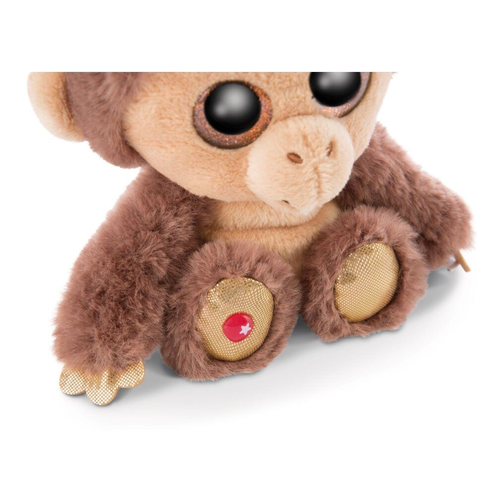 Dettaglio di una scimmia di peluche. Pelliccia marrone, piedi beige con stella rossa. Dettagli dorati.
