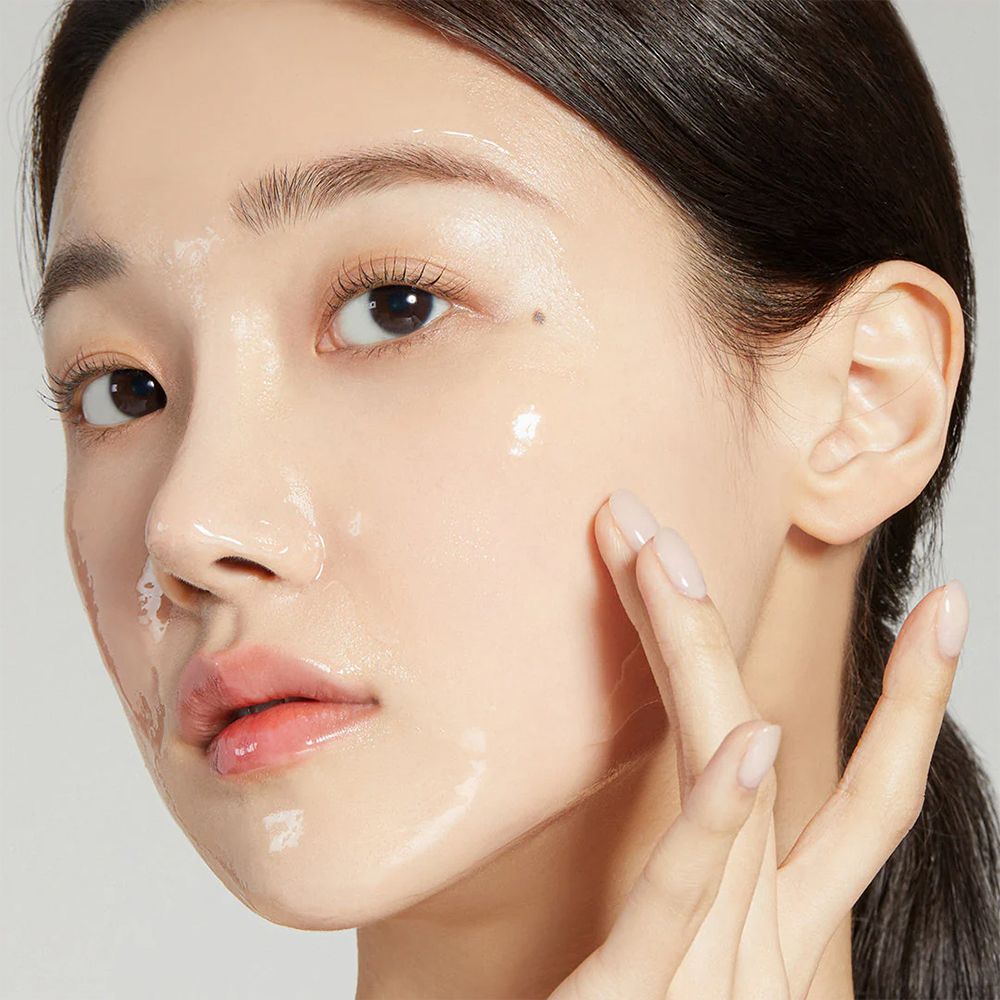 Una donna applica la 'Collagen Night Wrapping Mask' sul viso.