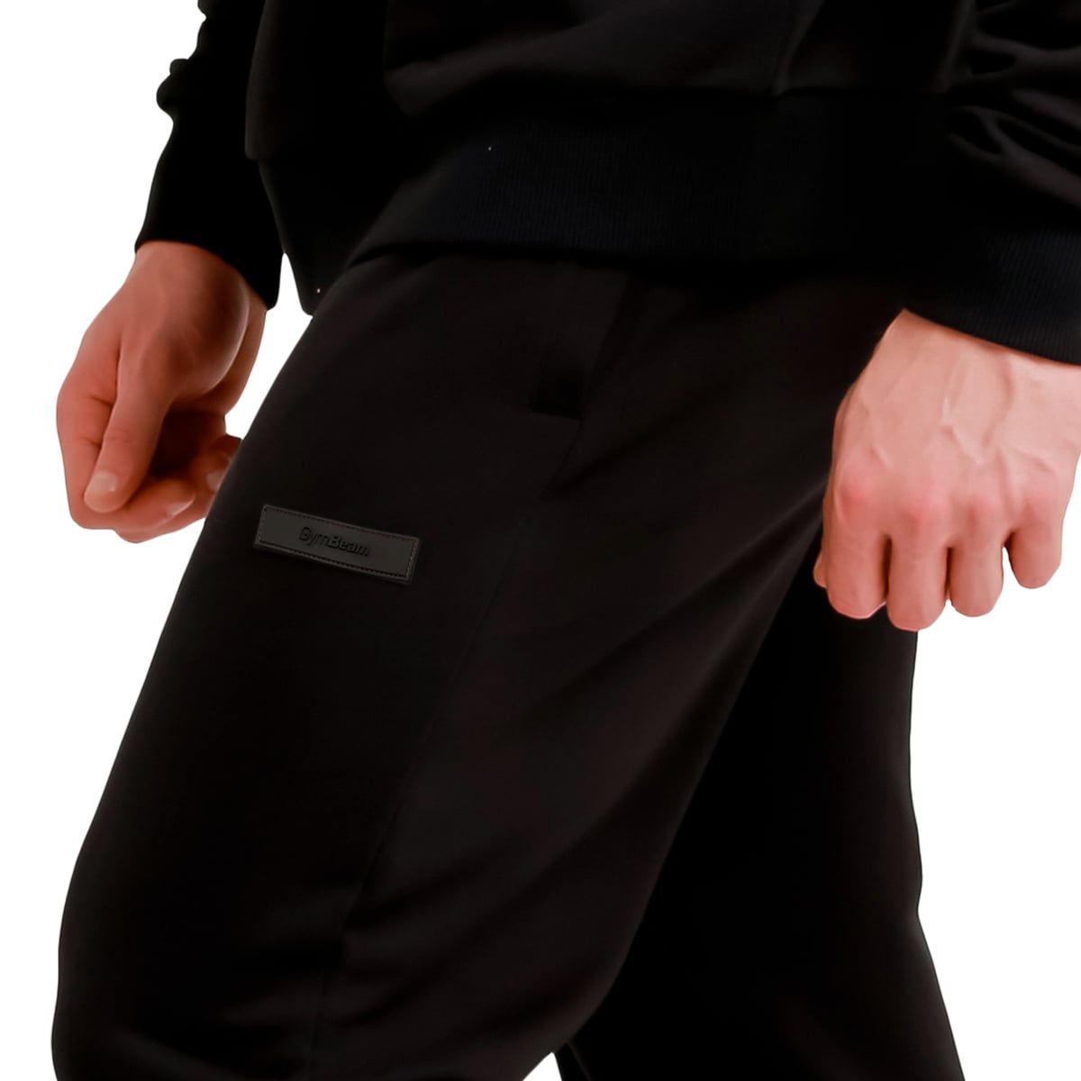 Vista dettagliata dei pantaloni da jogging neri da uomo con patch logo laterale.