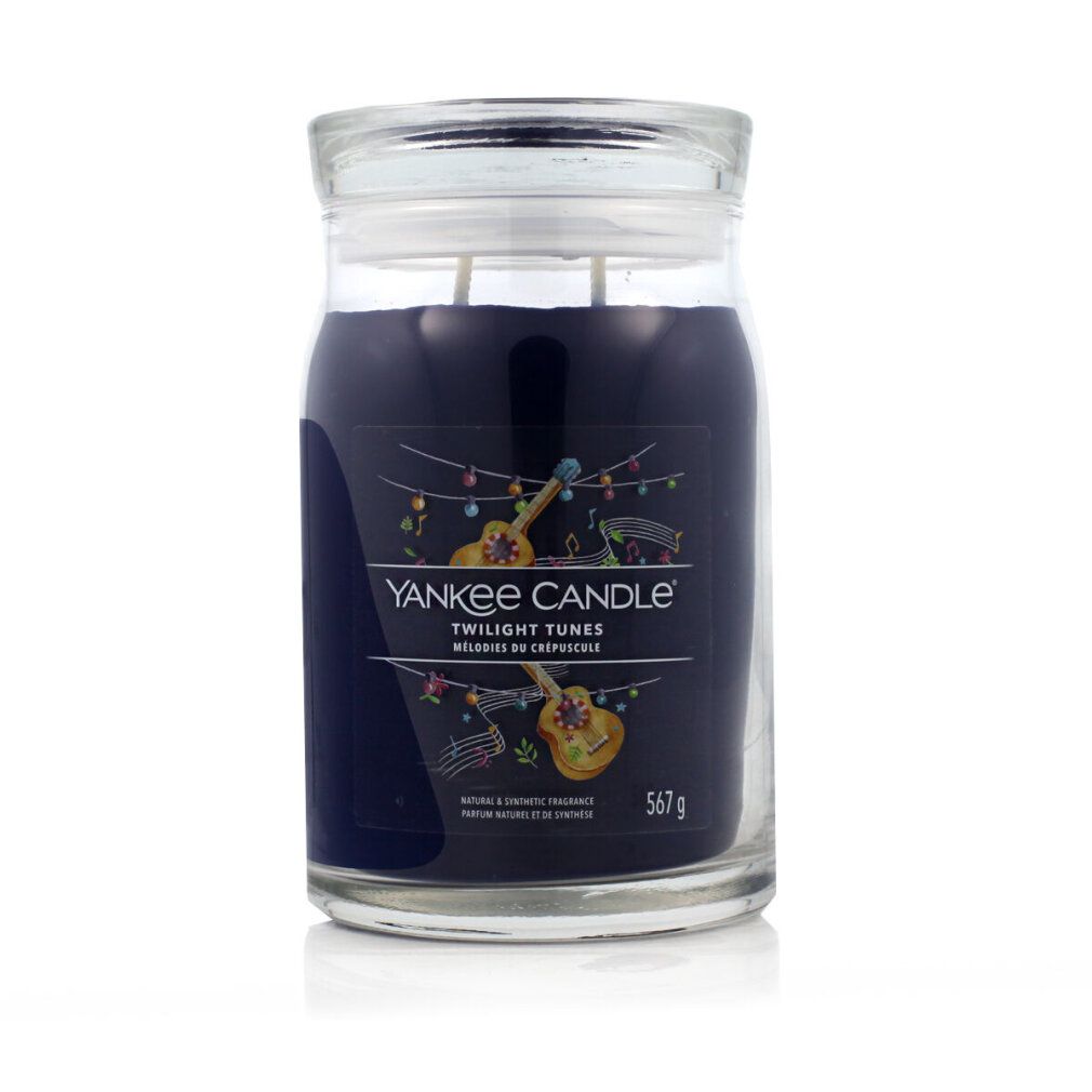Candela profumata in vetro con coperchio. Scritta: Yankee Candle Twilight Tunes. Illustrazioni di strumenti musicali. 567 g.