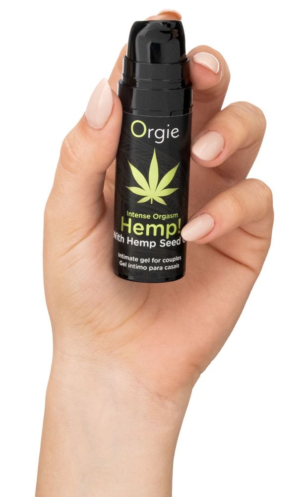 Mano che tiene flacone nero con foglia di cannabis verde e testo: Intense Orgasm Hemp! Gel intimo per coppie. Marchio: Orgie.