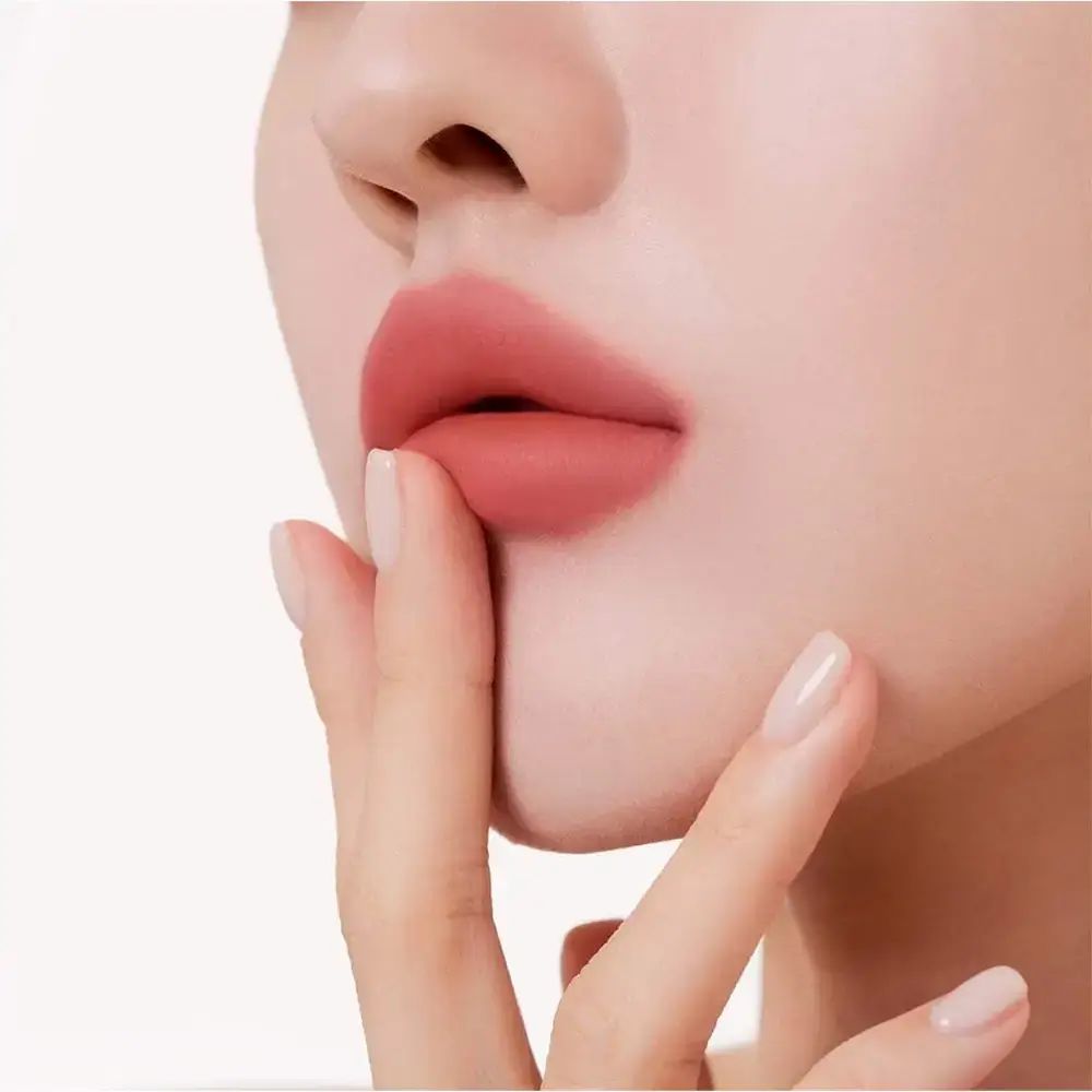 Labbra con MUZIGAE MANSION Objet Liquid Lip Tint 021 Melted. Dito sulle labbra. Rossetto color carne.