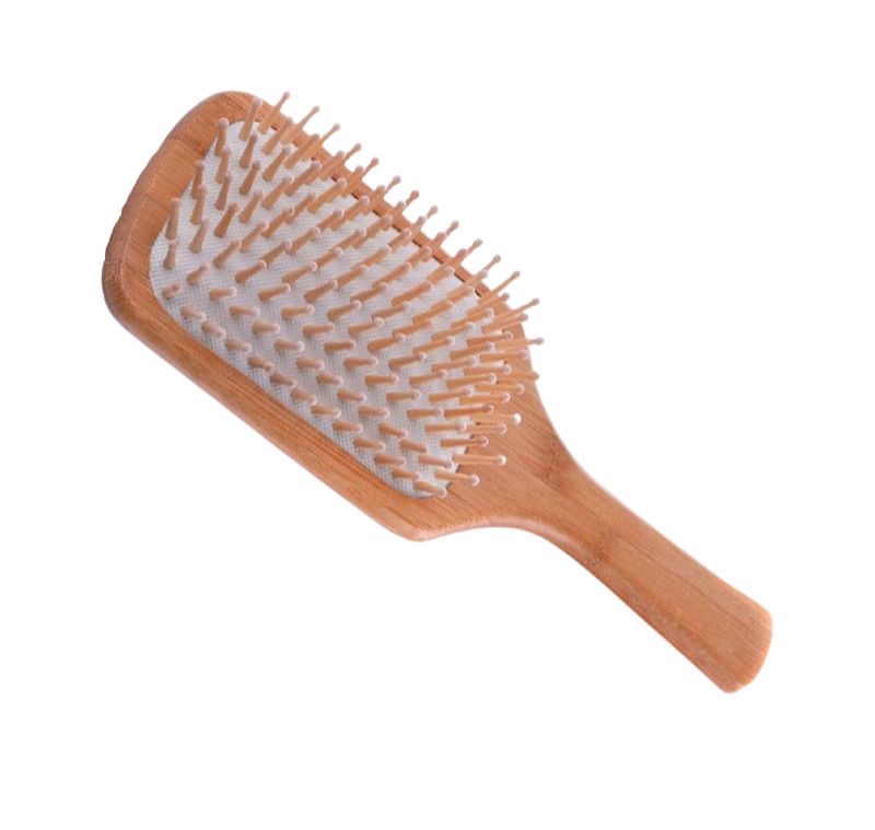 Spazzola per capelli in legno con testa rettangolare e manico, dotata di numerosi denti in legno su cuscino bianco.