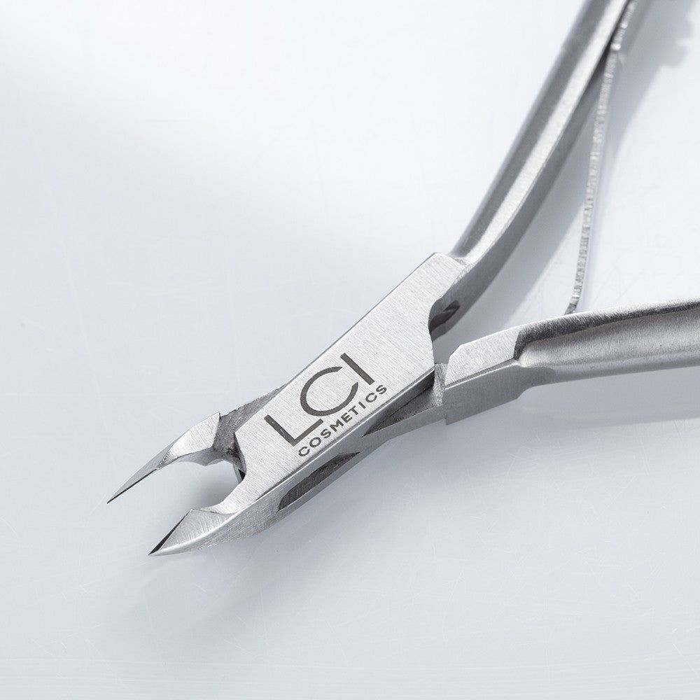 Primo piano della tronchesina. Logo LCI Cosmetics. Metallo, bordi taglienti. Dettaglio della zona di taglio.