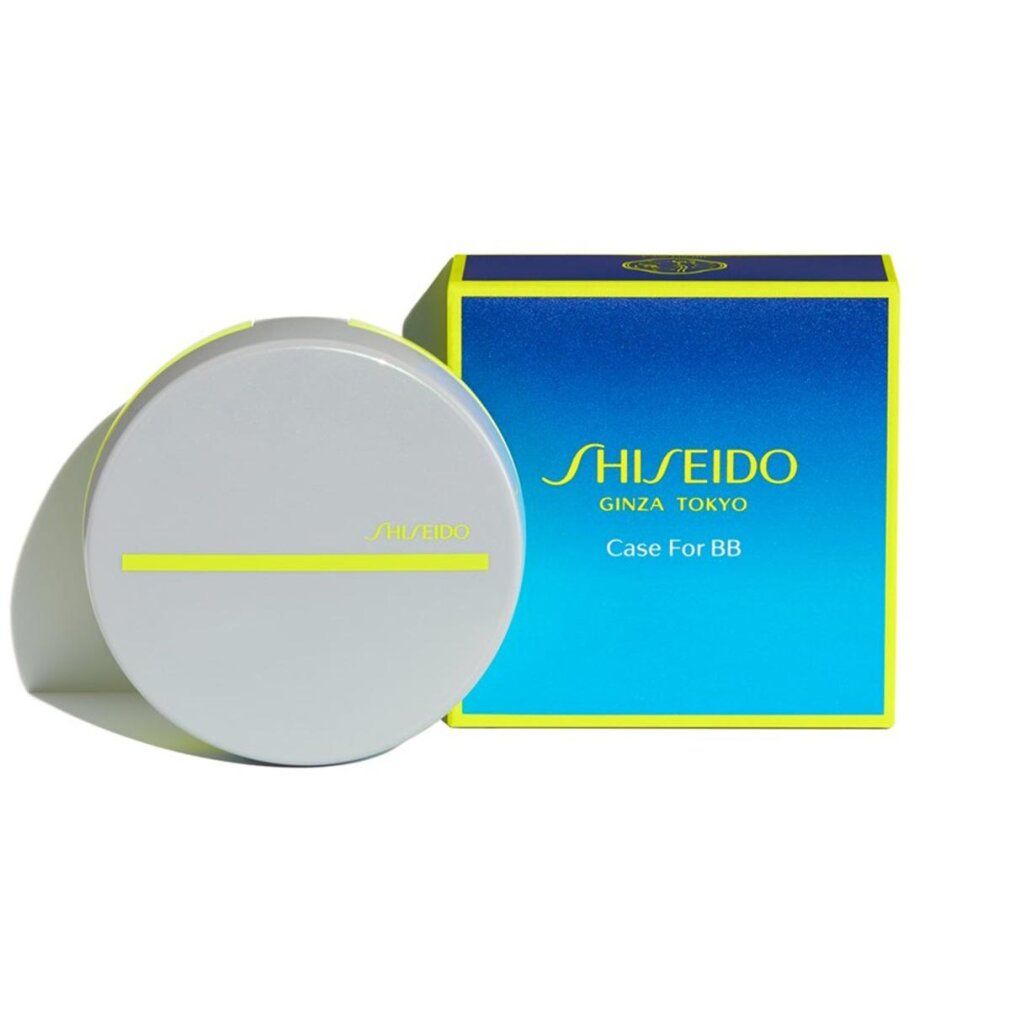 Contenitore compatto grigio con linea gialla. Accanto, scatola blu con logo SHISEIDO e testo.