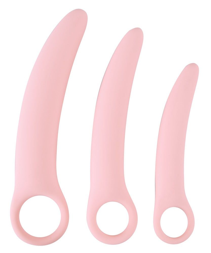 Tre allenatori vaginali rosa. Con anello. Su sfondo bianco.