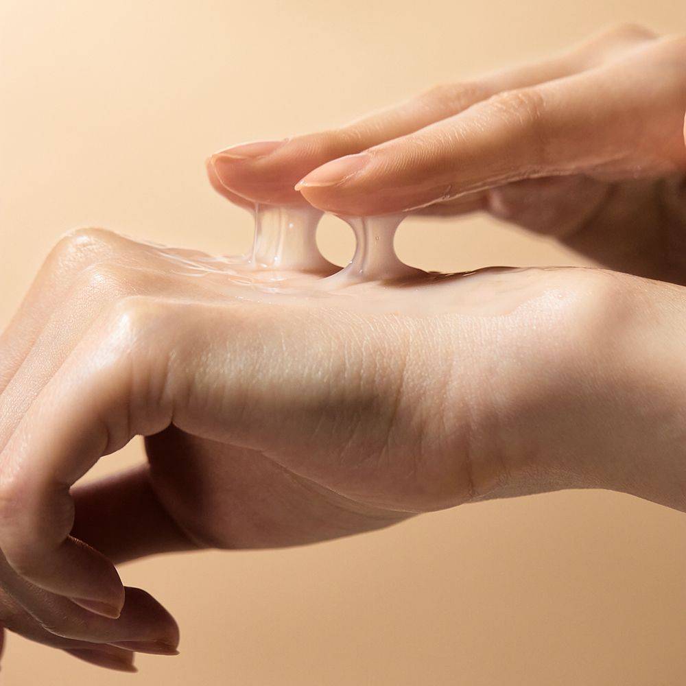 Mani con liquido cremoso. Liquido tenuto tra le dita.