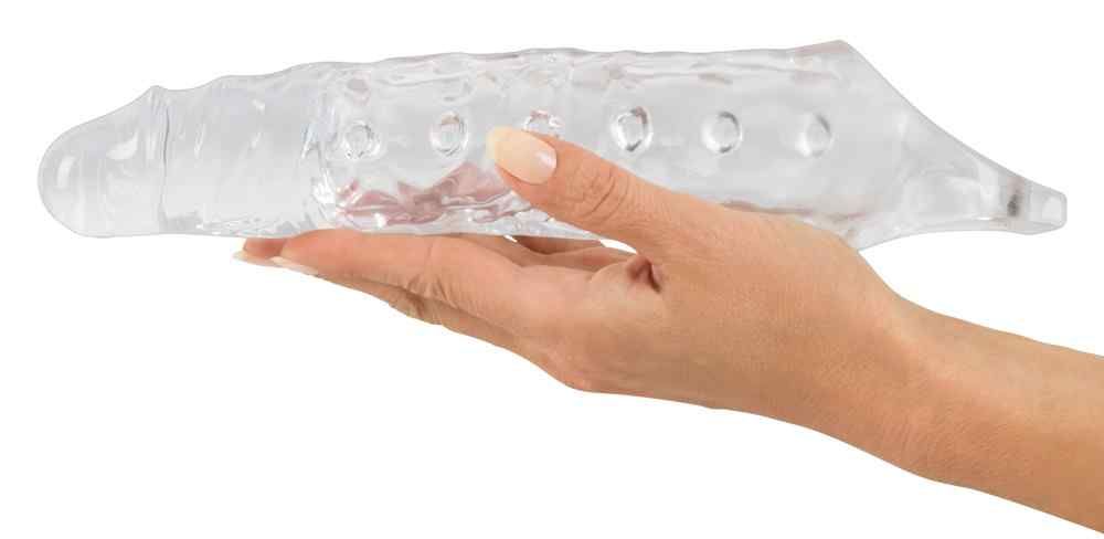 Mano che tiene una guaina peniena trasparente con bottoni e anello testicolare.