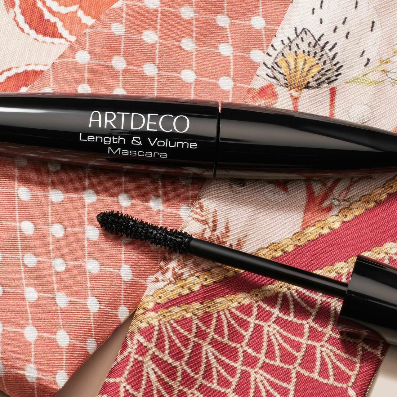 Tubo e spazzola per mascara neri su tessuto. Sul tubo è scritto "ARTDECO Length & Volume Mascara".