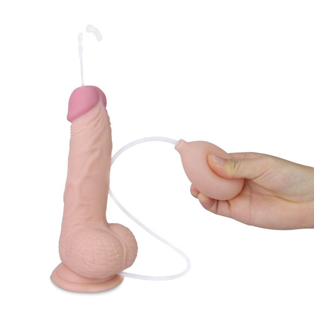 Dildo beige con punta rosa. Pompa e tubo. Mano che tiene la pompa.