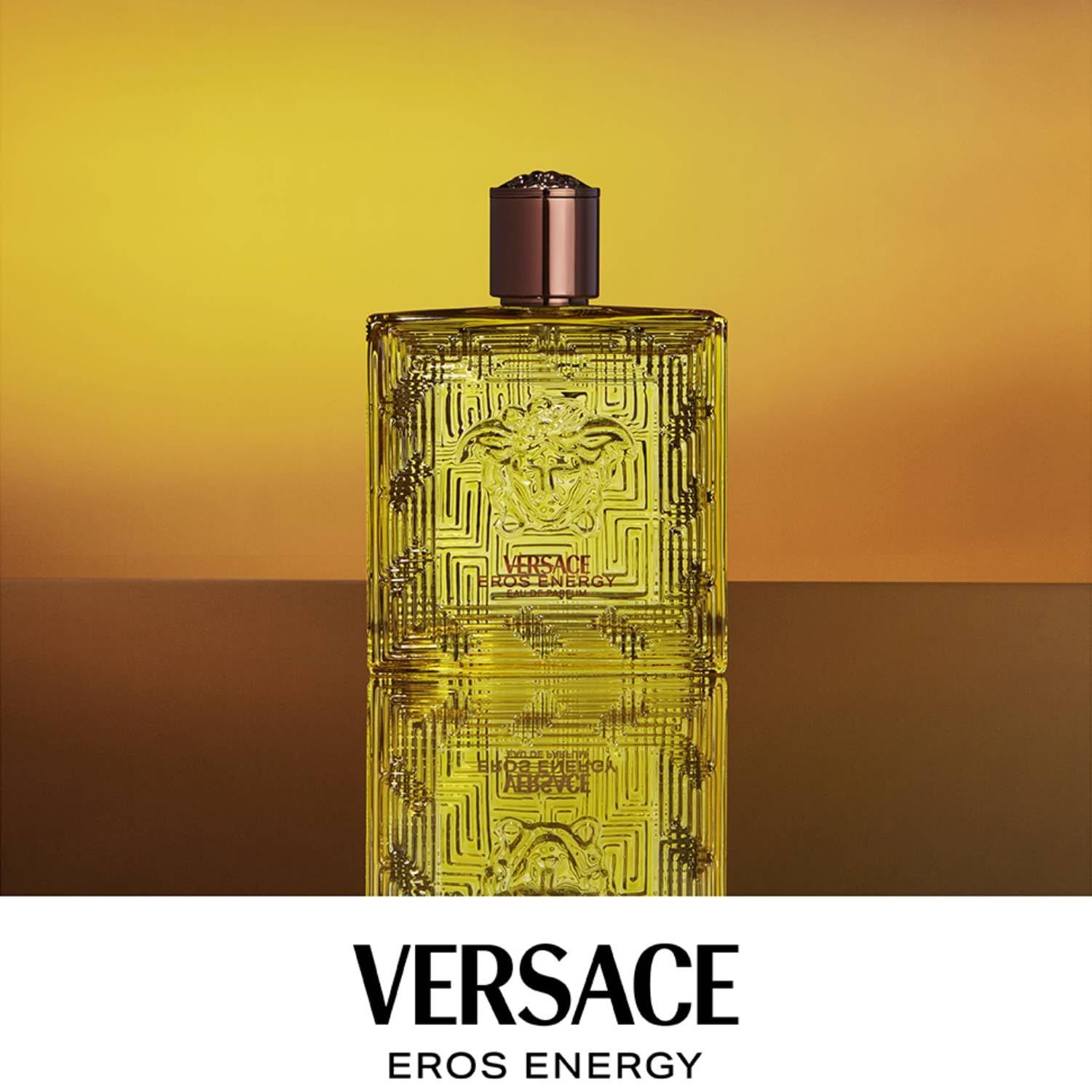 Flacone giallo Versace Eros Energy. Tappo marrone. Forma quadrata con motivo in rilievo. Logo Versace visibile.