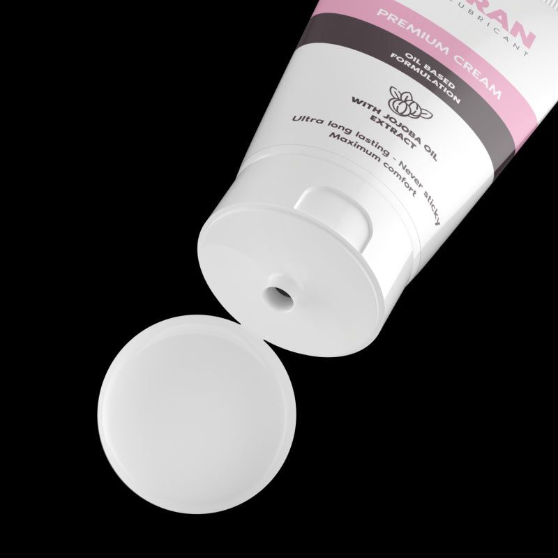 Tubo bianco con tappo aperto. Il prodotto viene spremuto dal tubo. Sfondo nero.