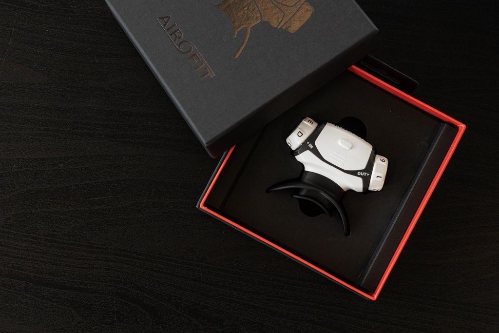 Allenatore respiratorio bianco in scatola nera. Scatola aperta con logo Airofit.