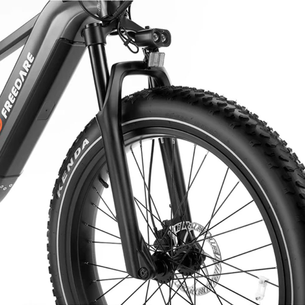 Primo piano della forcella anteriore e dello pneumatico di una bicicletta elettrica nera. Pneumatici Kenda.