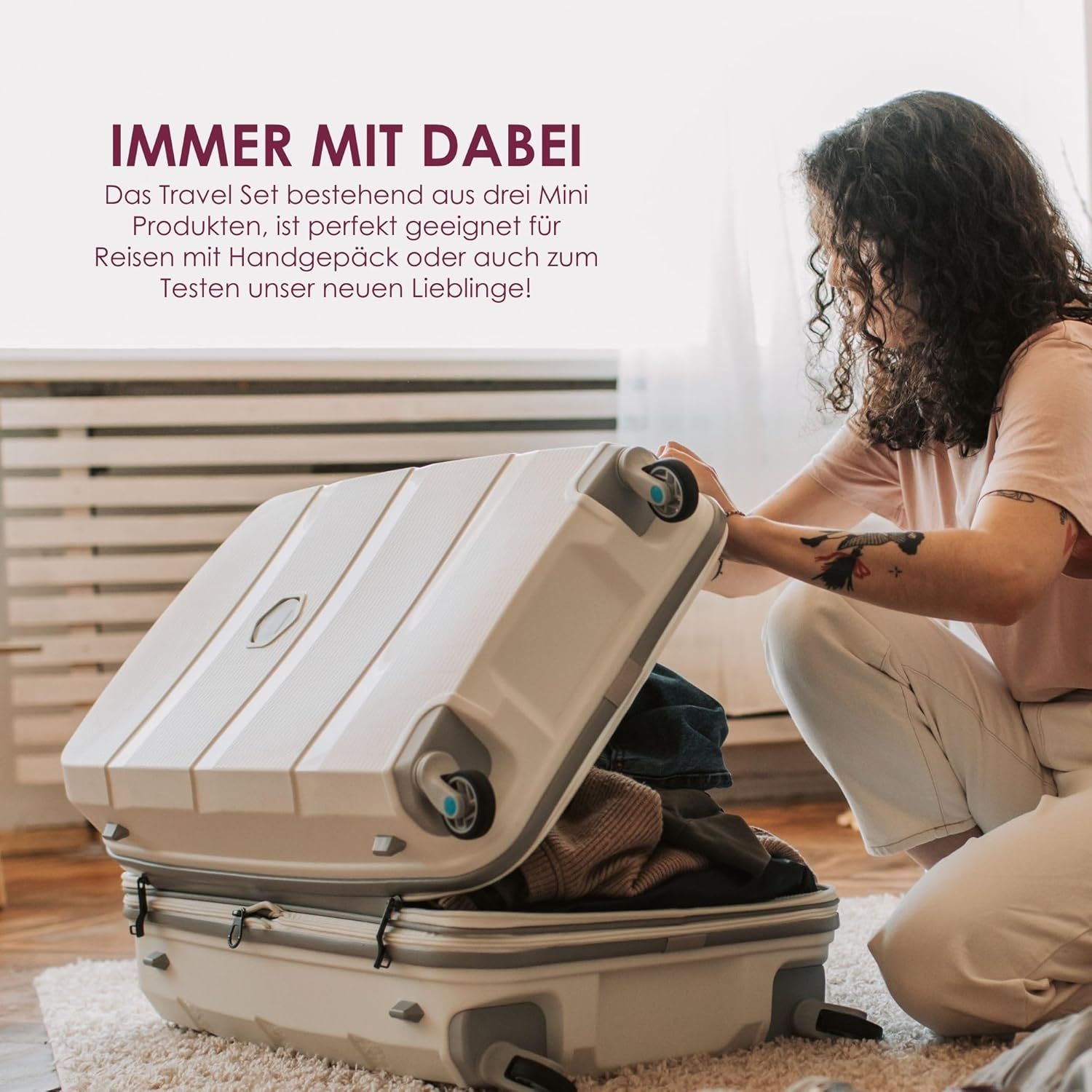 Donna apre una valigia. Testo: IMMER MIT DABEI. Travel Set con 3 mini prodotti, ideale per viaggiare.