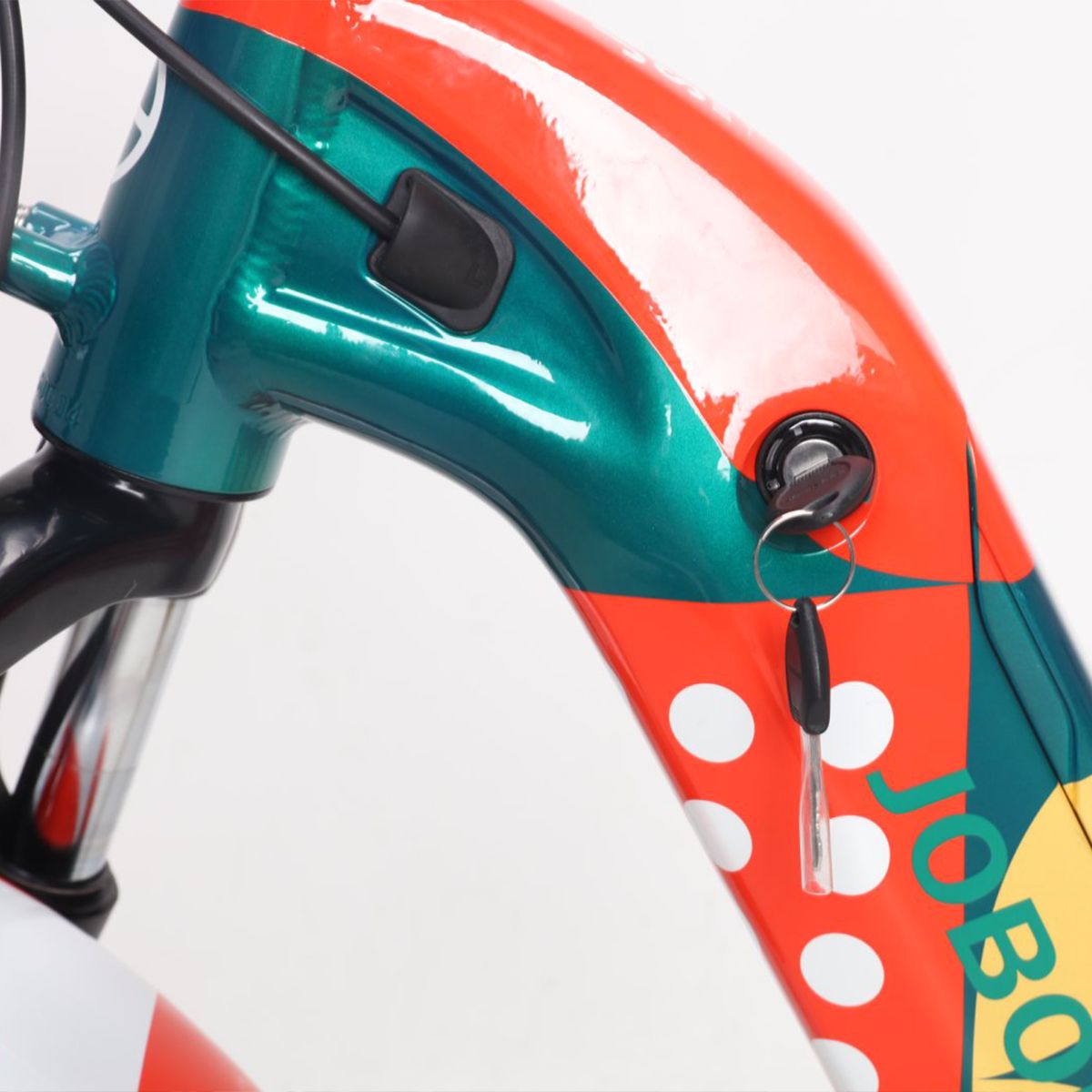 Telaio e serratura di una e-bike. Design verde-rosso con pois bianchi. Chiave nella serratura. Logo JOBOBIKE visibile.